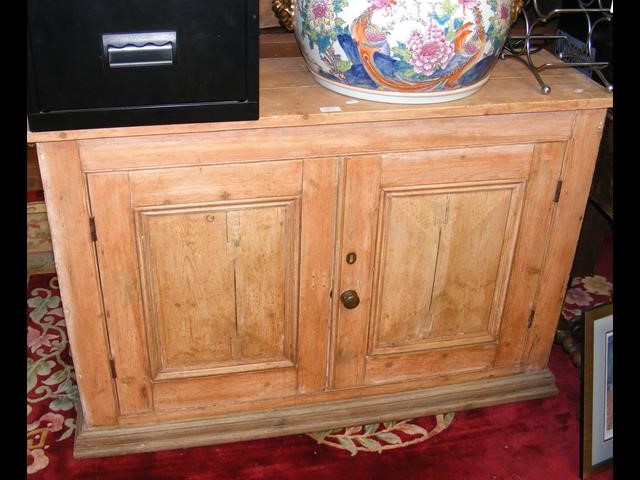 A stripped pine side cabinet - width 116cms