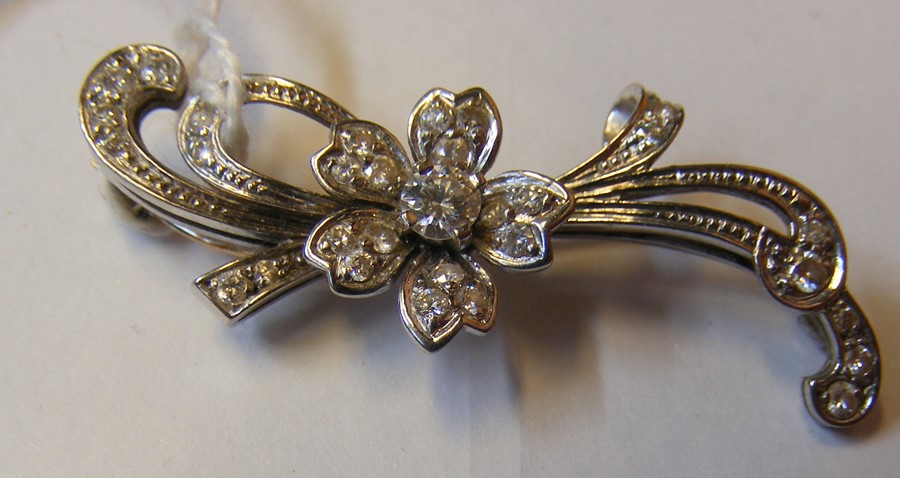 A diamond mounted flower brooch in white gold sett