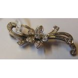 A diamond mounted flower brooch in white gold sett