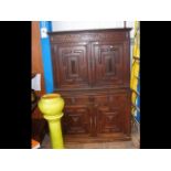 An antique oak cupboard with two drawers to the fr