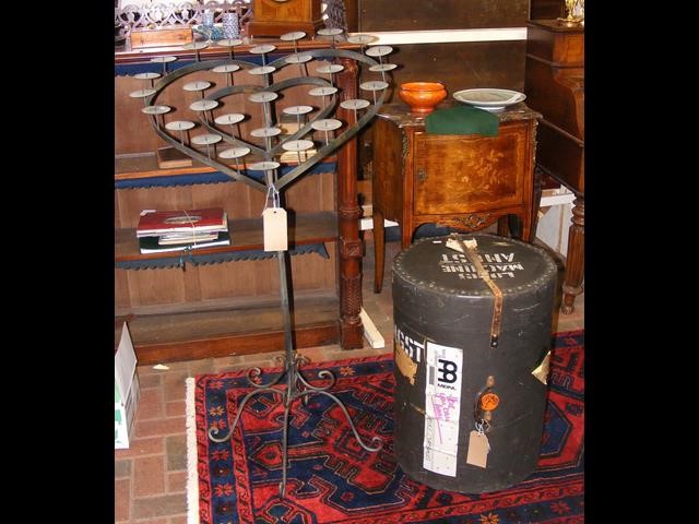 A heart shaped wrought iron candle stand together