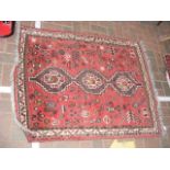 A small Middle Eastern rug with red ground and geo