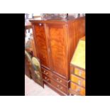 A mahogany utility cupboard with two swing doors a