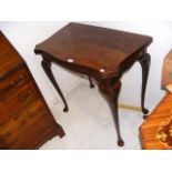A reproduction walnut card table with shaped top -
