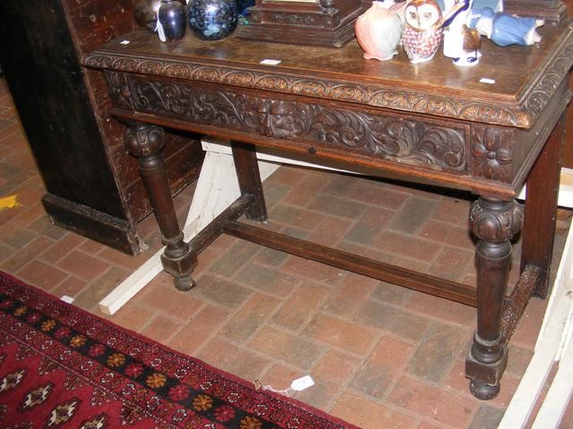 A Victorian carved oak side table with drawer unde