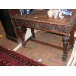 A Victorian carved oak side table with drawer unde