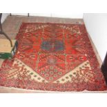 A Middle Eastern style rug with red ground and geo