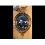 A Regency style convex mirror with eagle surmount