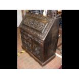 A late Victorian carved oak bureau with four drawe