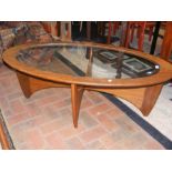 A retro oval G-Plan glass top and teak coffee tabl