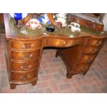 A reproduction serpentine fronted knee hole desk w