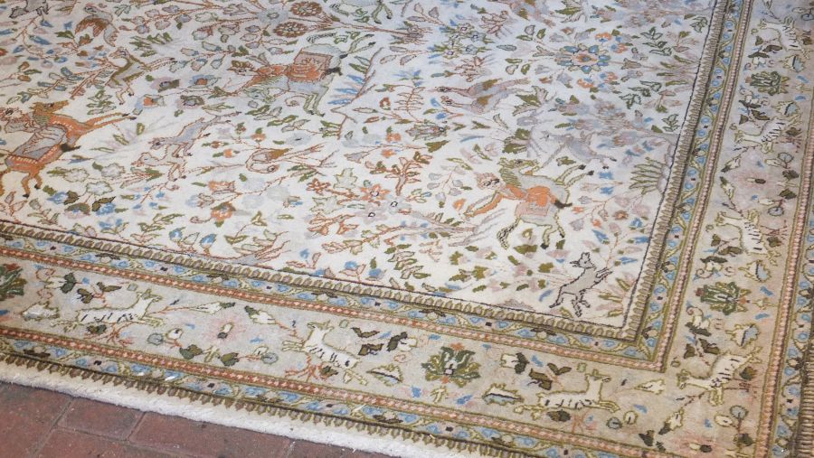 A Persian light ground bordered carpet with huntin - Image 2 of 6