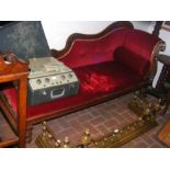 A Victorian chaise lounge upholstered in red velou