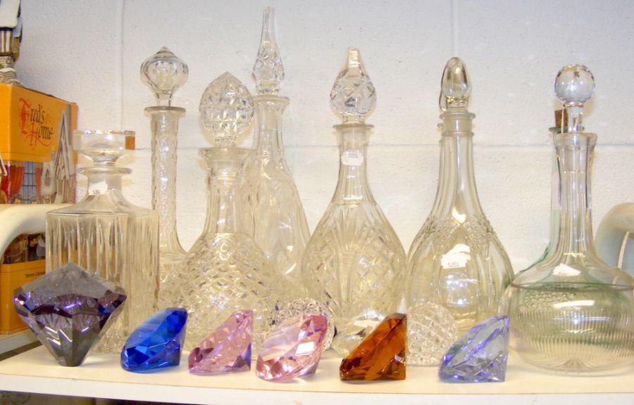 A cluster of cut glass decanters, stoppers and col