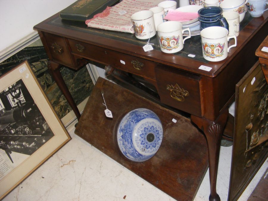 A writing desk with green leather top and three dr