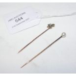 A clover leaf tie pin and one other