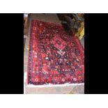 A Middle Eastern rug with red ground - 220cm x 145