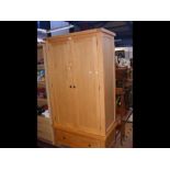 A modern light wood two door wardrobe with drawer