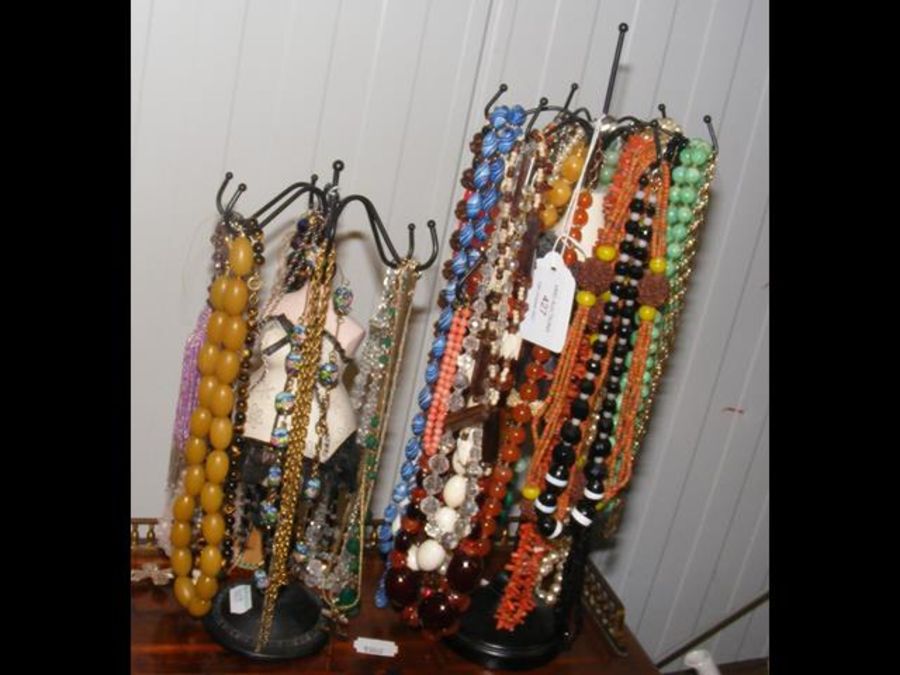 An assortment of costume necklaces on miniature ma