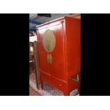 Oriental red lacquered two door cupboard with deco