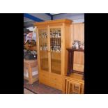 A modern light wood two door display cabinet with