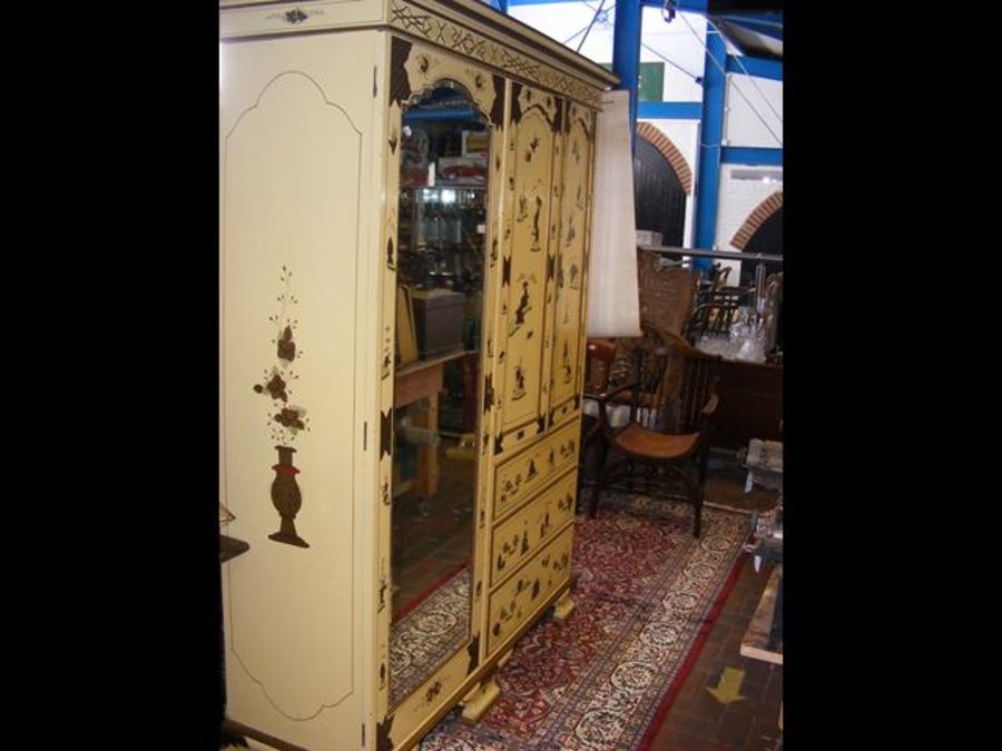 A Japanned antique wardrobe with mirrored bevelled