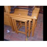 A nest of three light wood occasional tables