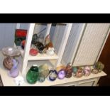 A selection of glass paperweights, stone eggs and