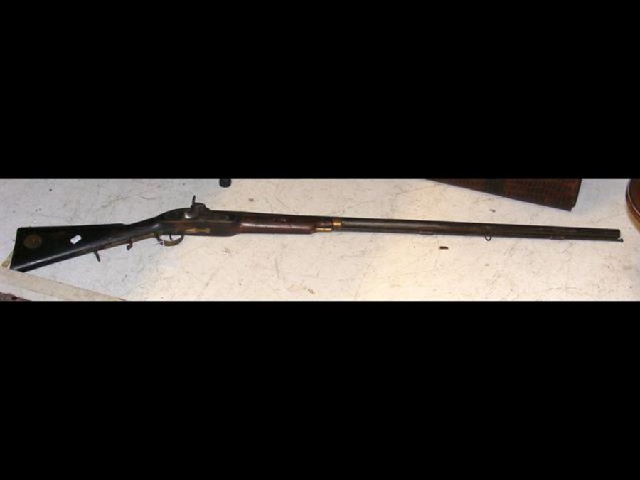 An antique rifle with engraved side plate and meta