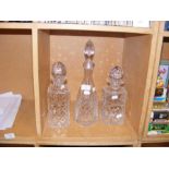 A cut glass decanter and two others