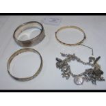 A silver bangle, charm bracelet, etc.