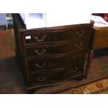 A reproduction serpentine fronted four drawer ches