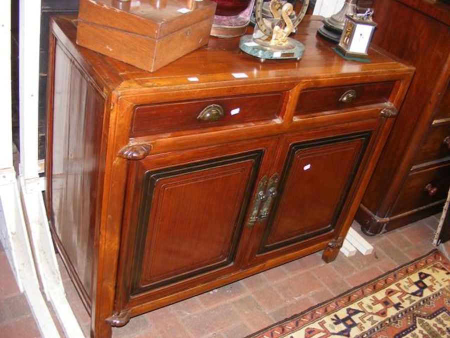 A sideboard with panelled doors and two drawers to