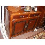 A sideboard with panelled doors and two drawers to