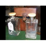 A pair of cologne bottles with silver and