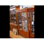 A display cabinet with two glazed doors and four d