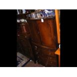 A mahogany bow front drinks cabinet with faux draw