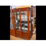 A display cabinet with two glazed doors and four d