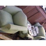 A light green upholstered wing back easy chair, to