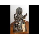 An Indian cast bronze of Hindu goddess playing ins