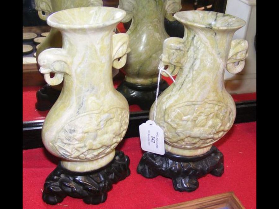 A pair of 18cm high carved oriental vases on woode