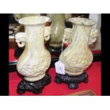 A pair of 18cm high carved oriental vases on woode