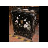 A black lacquered oriental cabinet with carved bir