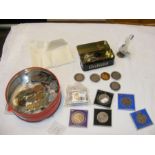 A tin containing various collectable coinage, crow