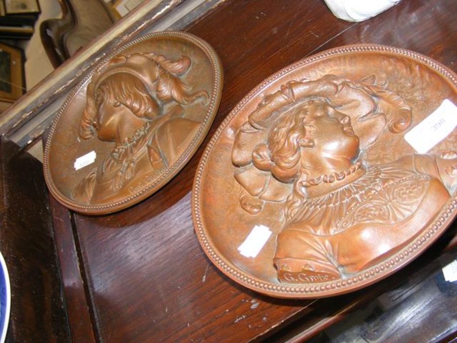 A pair of bronze coloured plaques - 19cm diameter