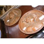 A pair of bronze coloured plaques - 19cm diameter