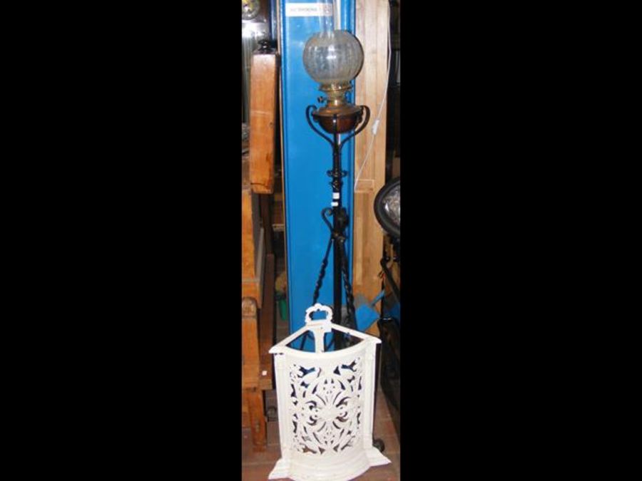 An oil lamp on wrought iron stand together with ca