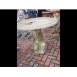 A concrete circular garden table on decorative sup