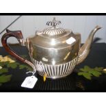 A silver teapot with fluted design