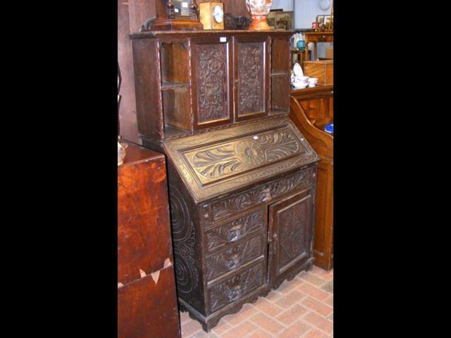 A carved oak bureau bookcase with fitted interior